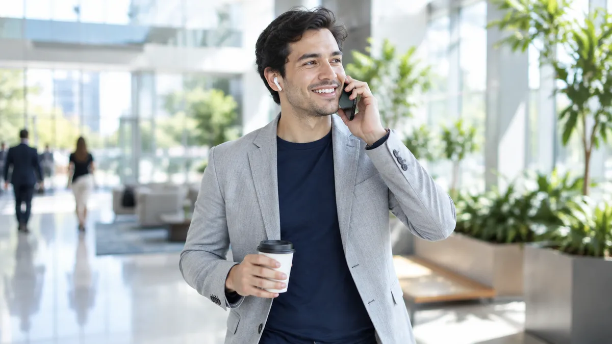 Un ejecutivo de cuentas habla por teléfono mientras cruza el vestíbulo de su oficina